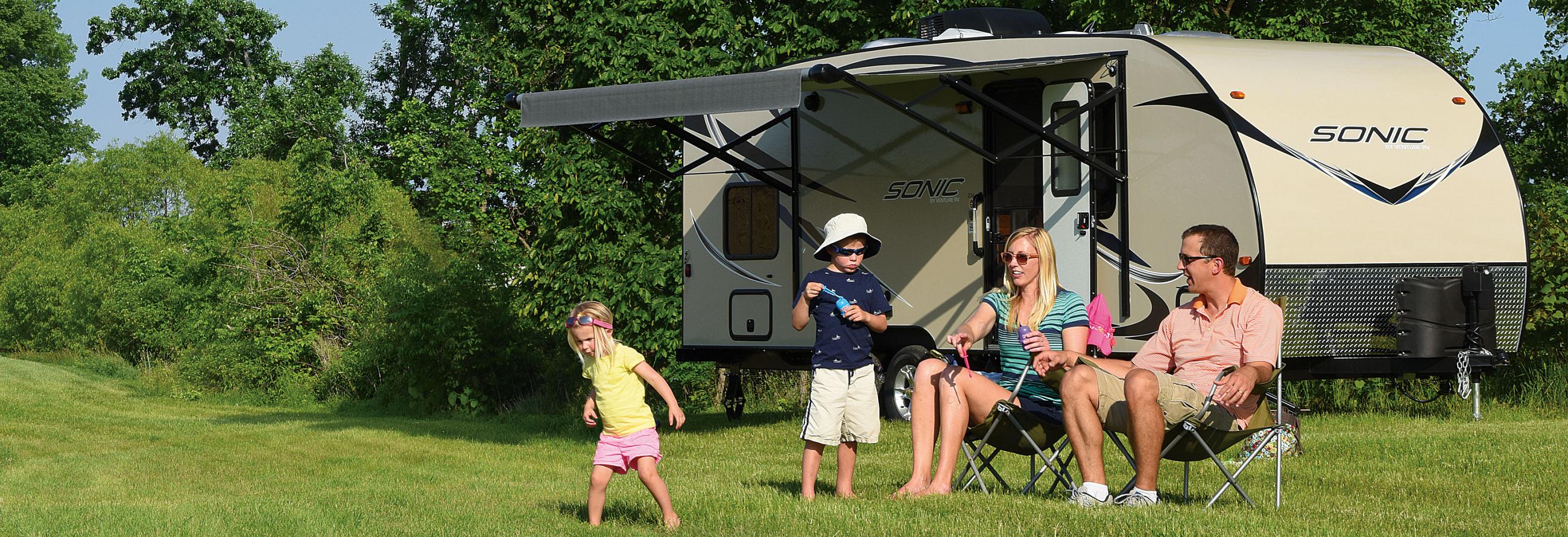 Family camping and playing with bubbles while enjoying their 2016 Sonic SN234VBH Travel Trailer