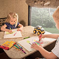 Kids coloring at the dinette table in their 2016 Sonic SN234VBH Travel Trailer