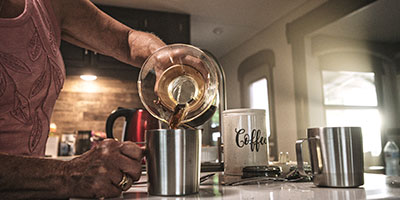 2020 Venture RV SportTrek Touring Edition STT343VIK Travel Trailer with woman pouring coffee in kitchen
