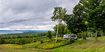 2021 Venture RV Sonic X SN211VDBX Travel Trailer at Campsite in the Distance