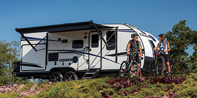 2022 Venture RV Sonic X SN220VRBX Travel Trailer with Biking Couple at Campground