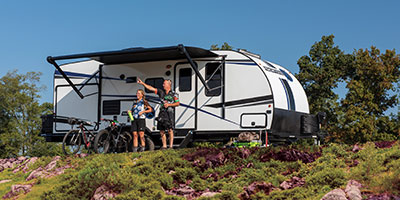 2022 Venture RV Sonic X SN220VRBX Travel Trailer with Biking Couple at Campsite