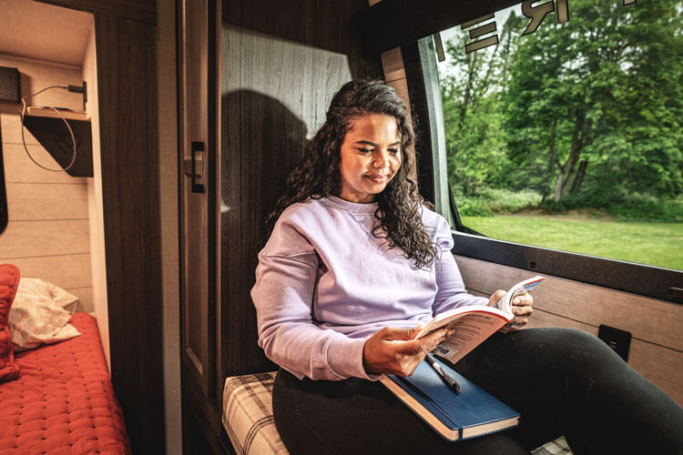 2026 Venture RV SportTrek Touring Edition STTF353VRK Fifth Wheel with Woman Reading on Window Seat